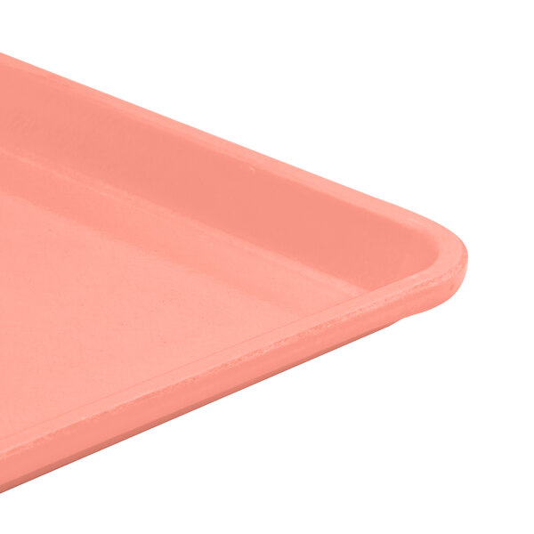 A close up of a pink Cambro dietary tray on a table.