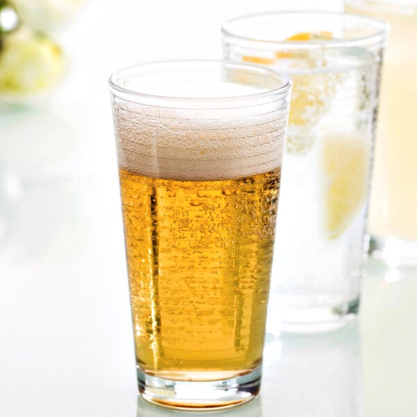 Two Fortessa Basics Arcade beverage glasses, one filled with beer with foam and one with water.