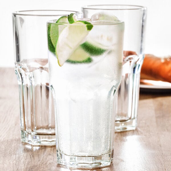 A close-up of a Fortessa Basics Chez Bistro Cooler Glass full of water and lime slices.