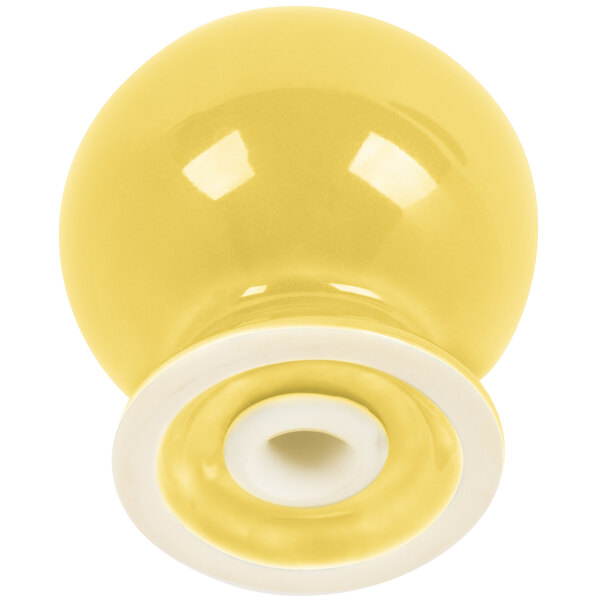 A yellow and white ceramic Fiesta pepper shaker with a white rim and swirl.