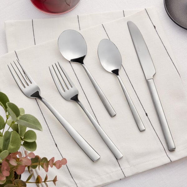 An Acopa stainless steel flatware sample set with a fork, knife, and spoon on a white napkin.