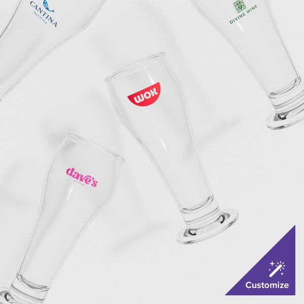 A group of clear footed pilsner glasses with a logo on one.