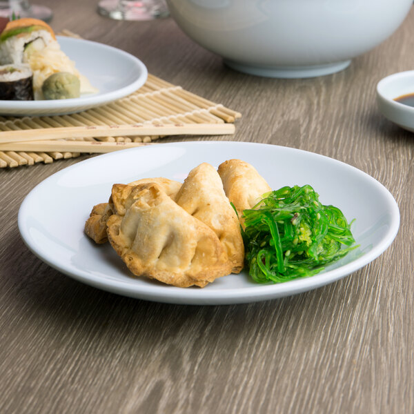 A blue Thunder Group Blue Jade melamine plate with sushi and vegetables on a table.