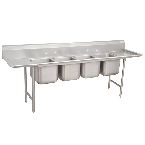 A stainless steel Advance Tabco four compartment sink with two drainboards.