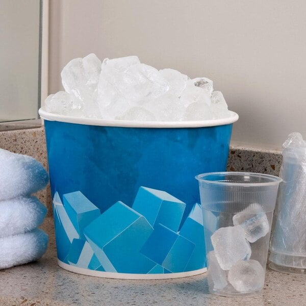 A Lavex disposable paper ice bucket filled with ice cubes next to a plastic cup.