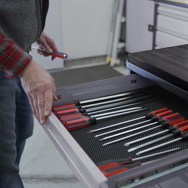 A person using a Valley Craft workbench drawer to hold tools.