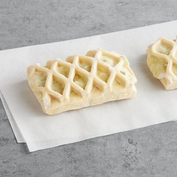 Two Bridor Parmesan Leek pastries on a piece of paper.