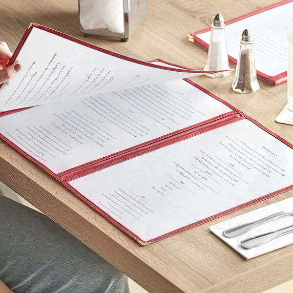 A person reading a burgundy Choice trifold menu at a restaurant.
