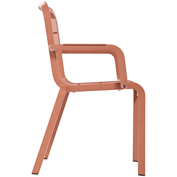 A Grosfillex Cannes resin outdoor armchair with terra cotta color and armrests.