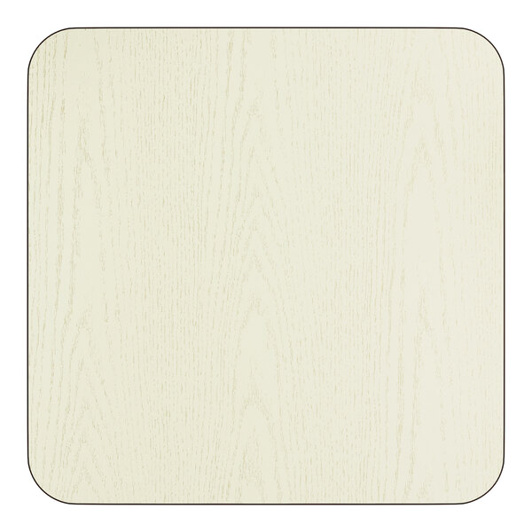 A square, reversible laminated table top in a light wood grain finish with rounded corners.