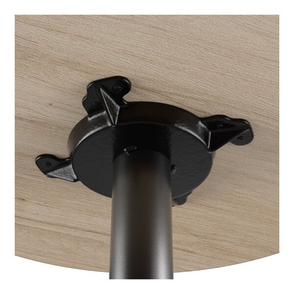 A close-up view of the underside of a round laminated bar height table showing the metal base attachment.