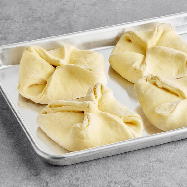 A tray of Bridor ready to bake butter danish dough on a gray surface.
