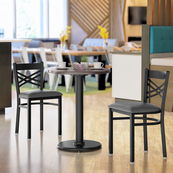 A Lancaster Table & Seating round table with a cast iron base in a restaurant dining area.