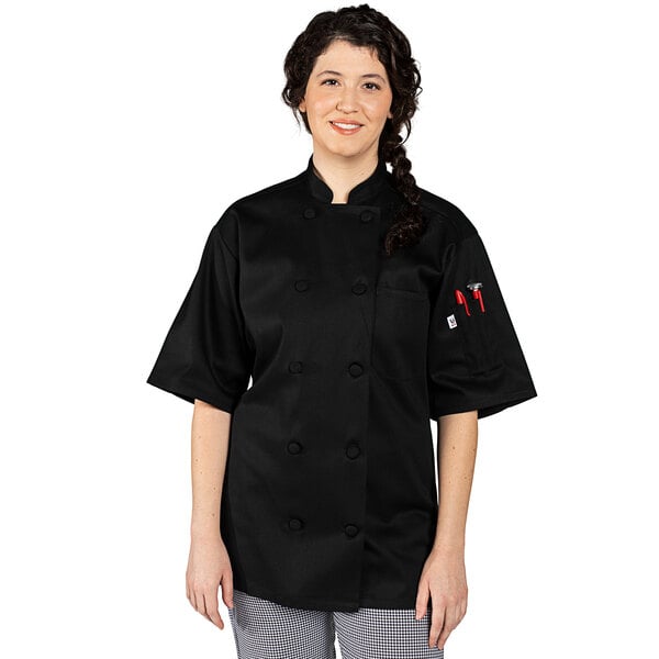 A woman wearing a black Uncommon Chef short sleeve chef coat.