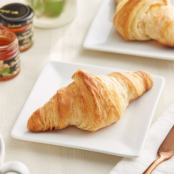 A white plate with a Bridor Butter Croissant on it.