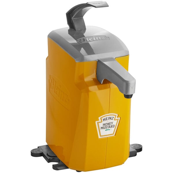 A yellow and grey Heinz countertop honey mustard pump dispenser on a counter.
