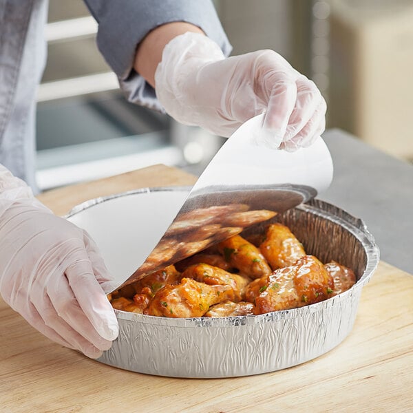 A person holding a Choice foil container with food in it.