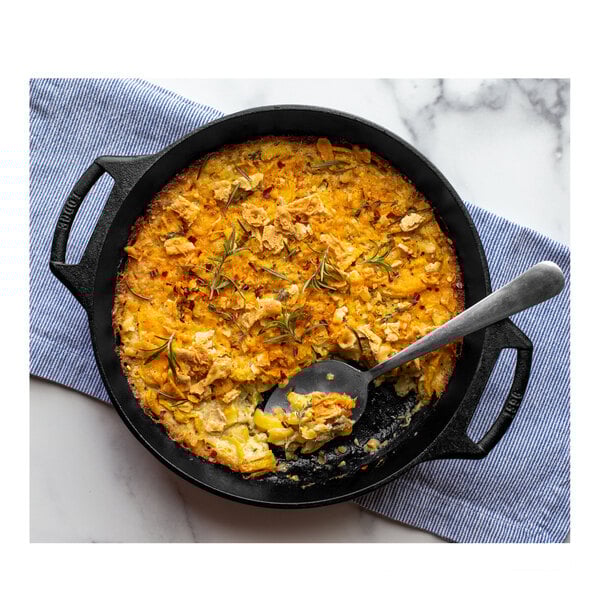 A Lodge cast iron baking skillet with food in it and a spoon.