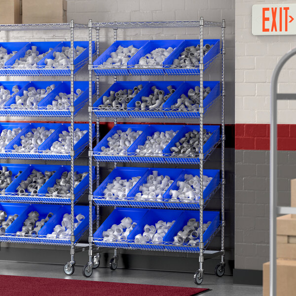 A Regency chrome metal shelving unit with slanted shelves holding blue bins.