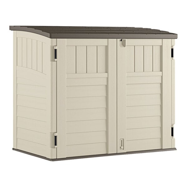 A white storage shed with brown trim.