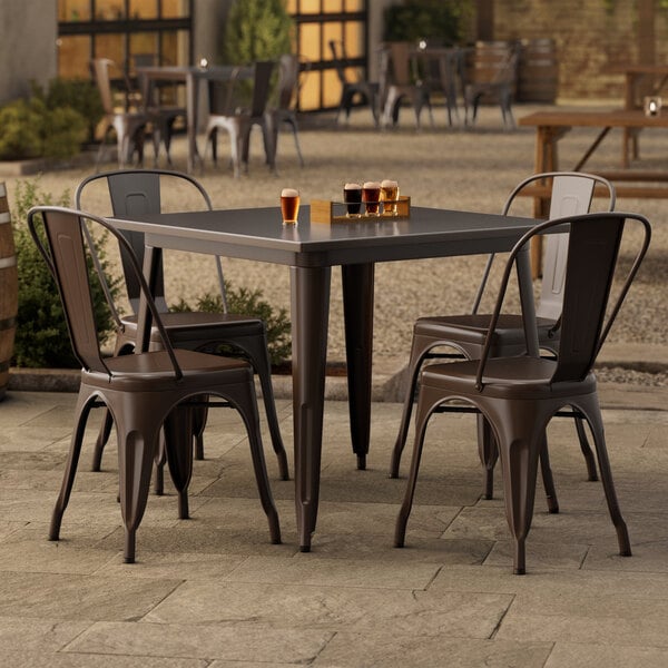 A Lancaster Table & Seating outdoor table with four chairs on a patio.