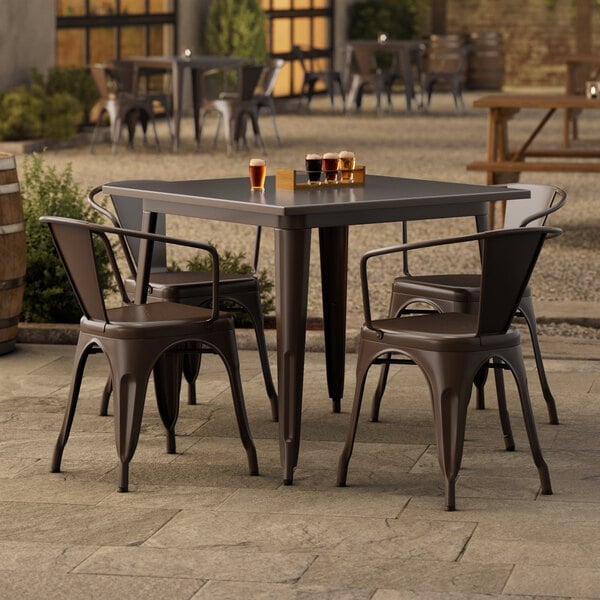 A Lancaster Table & Seating outdoor table and chairs on a patio.