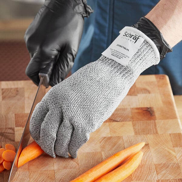 kitchen worker wearing cut resistant gloves while doing prep work