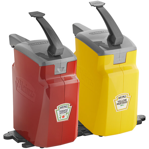 Two red and yellow plastic Heinz countertop pump dispensers with black handles.