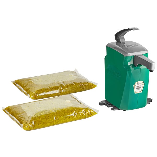 A green Heinz countertop pump dispenser with two Heinz Sweet Relish pouches inside.