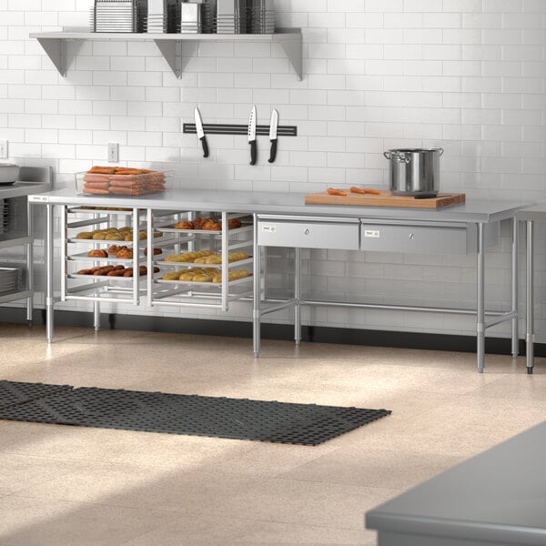 A Regency stainless steel open base work table in a school kitchen.