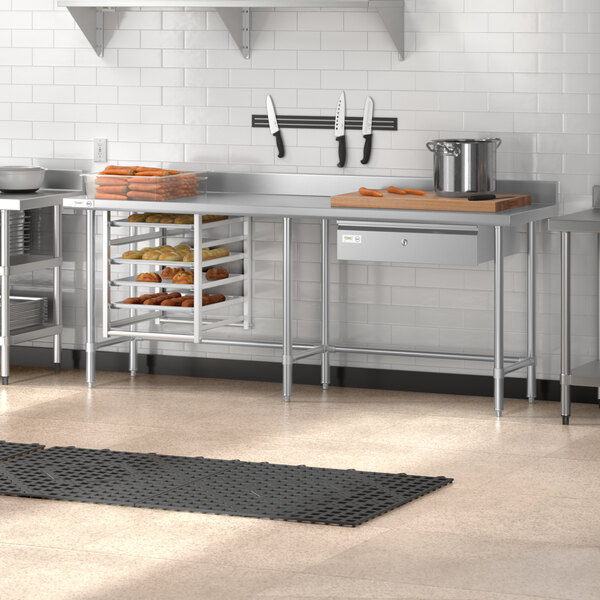 A Regency stainless steel open base work table in a kitchen with shelves.