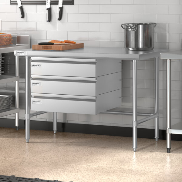 A Regency stainless steel open base work table in a professional kitchen.