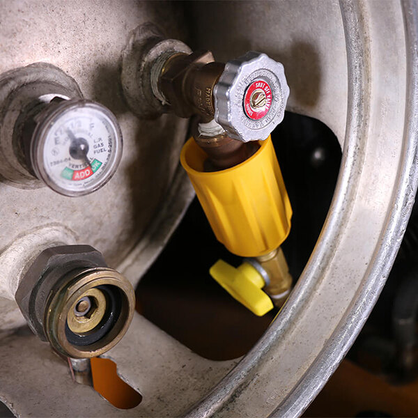 A close-up of a yellow valve with a yellow cap on a yellow tube.