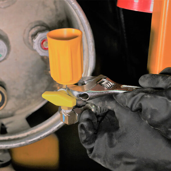 a person holding a wrench and a yellow tube