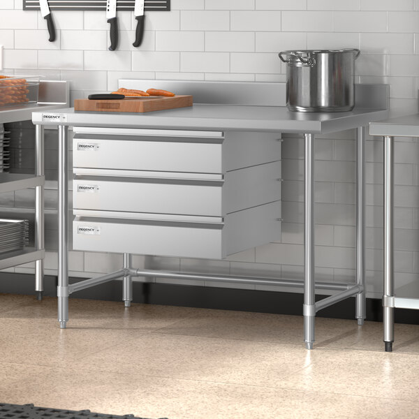 A Regency stainless steel work table in a professional kitchen.