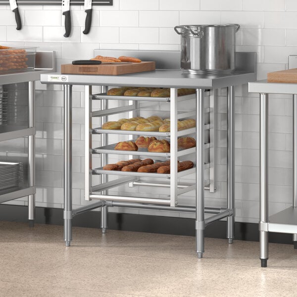 A Regency stainless steel open base work table with a metal tray of bread on it.