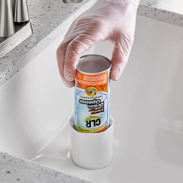 A hand in a glove holding a white and green pressurized can of CLR PRO PP-6 Drain Opener.