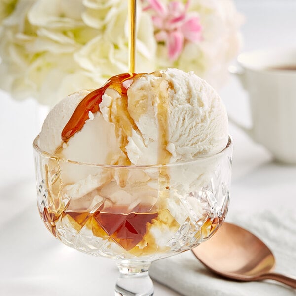 A glass cup of ice cream topped with Runamok Bourbon Barrel-Aged Maple Syrup.