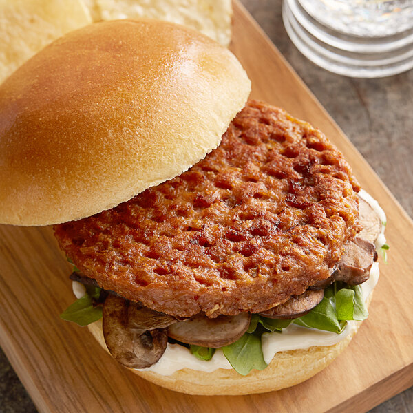 A Beyond Meat plant-based burger on a wooden cutting board.