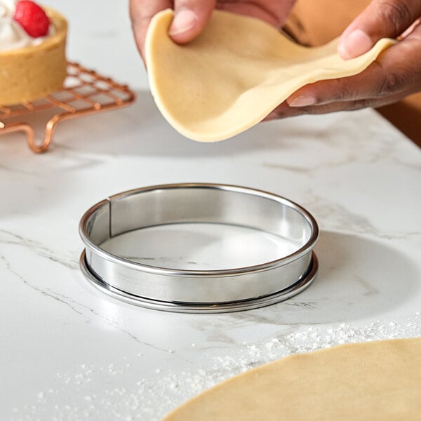 A stainless steel rolled edge tart ring used for baking tarts.