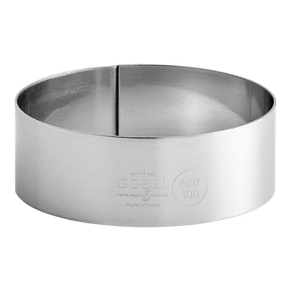 A Gobel stainless steel custard ring with a handle and a couple of holes.