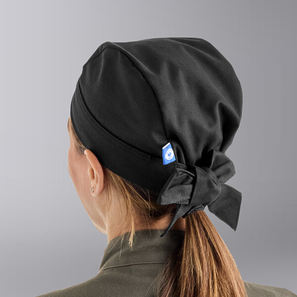 A woman wearing a black Uncommon Chef skull cap with ties.