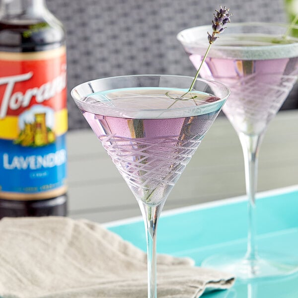 Two martini glasses with purple Torani lavender drinks on a table.