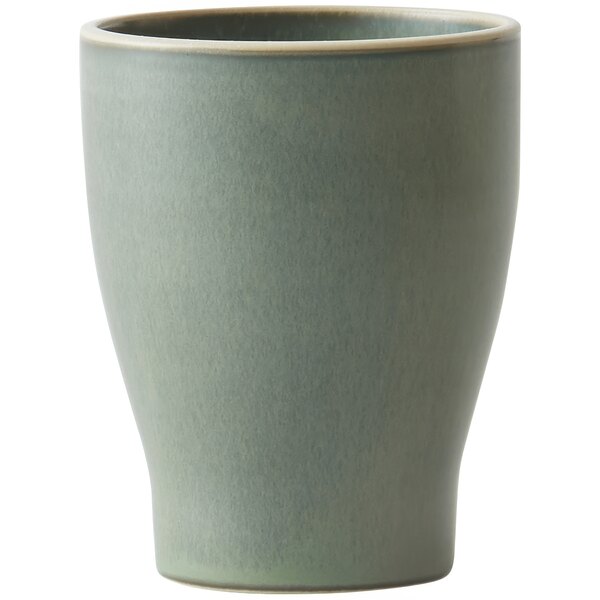 A close up of a Luzerne Smoky Basil stoneware tumbler. The tumbler is green.