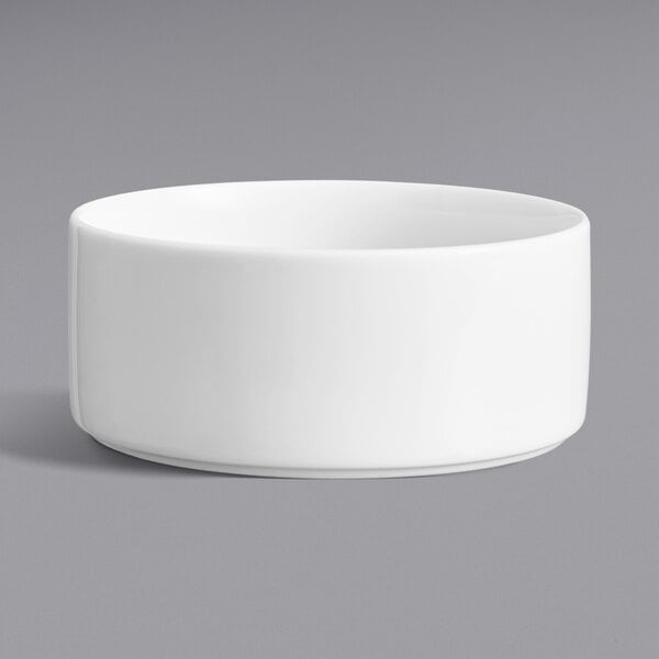 A Oneida Scandi bright white porcelain bowl with a raised rim on a gray surface.