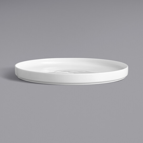 A close up of a Oneida Scandi bright white porcelain plate with a raised rim.
