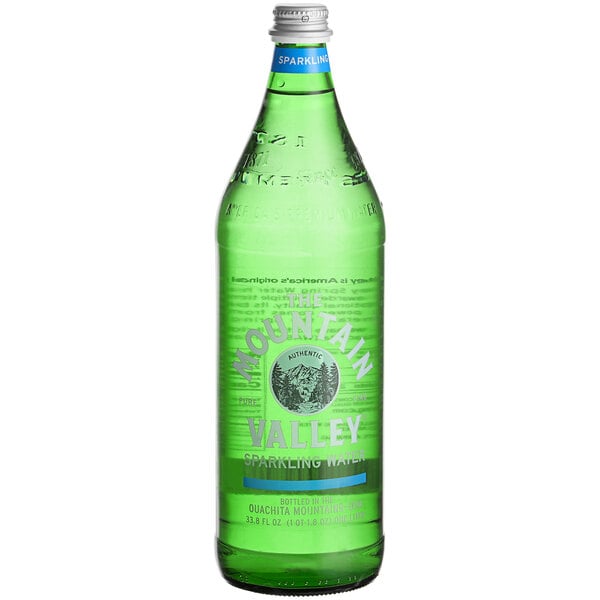A close up of a Mountain Valley Sparkling Water 1 liter glass bottle with a green label.