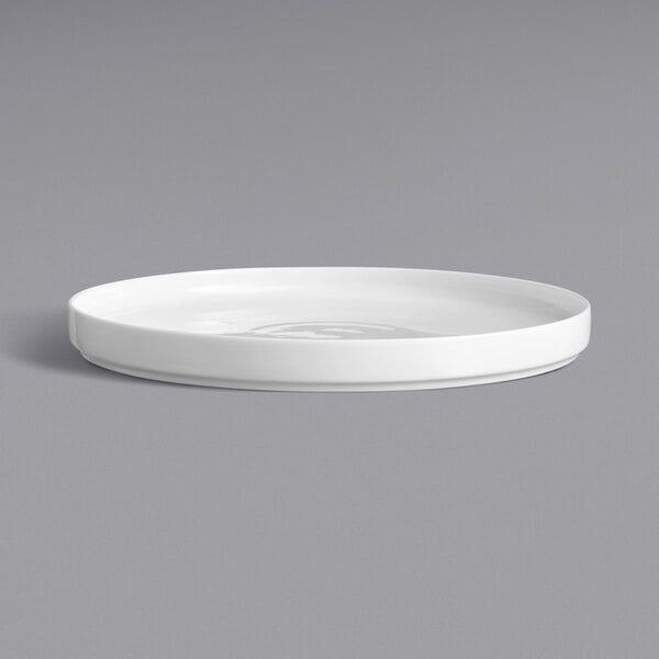 A close up of a Oneida Scandi bright white porcelain plate with a raised rim.