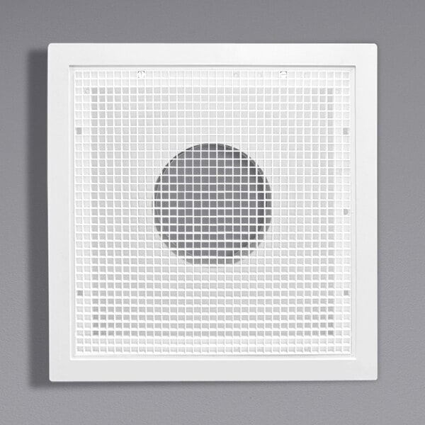 A white square vent with a grid pattern over a hole.