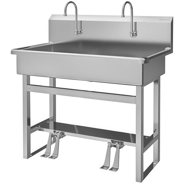 A Sani-Lav stainless steel utility sink with two foot-operated faucets.